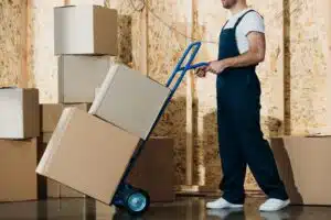 delivery man carrying boxes on hand truck