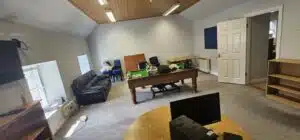 A cluttered office space with furniture, boxes, and office supplies, suggesting a commercial relocation in progress.