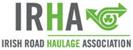 Logo of the Irish Road Haulage Association (IRHA), featuring bold grey text and a green circular graphic with a shamrock and an arrow, symbolizing transport and Irish heritage.