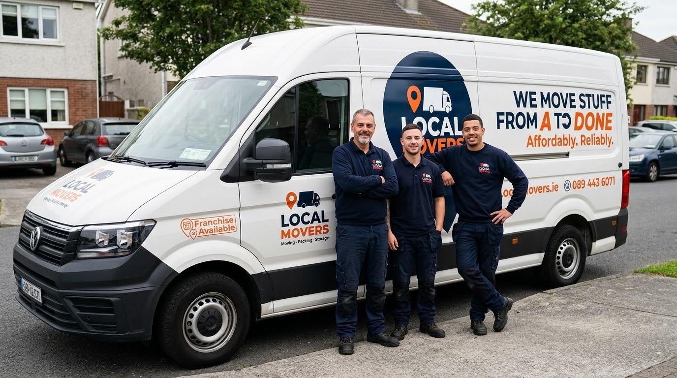 Three smiling local movers stand proudly in front of their white branded van, which displays "Local Movers" and "We Move Stuff From A to Done Affordably. Reliably.