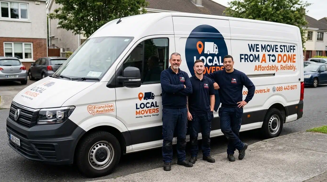 Three smiling local movers stand proudly in front of their white branded van, which displays "Local Movers" and "We Move Stuff From A to Done Affordably. Reliably.