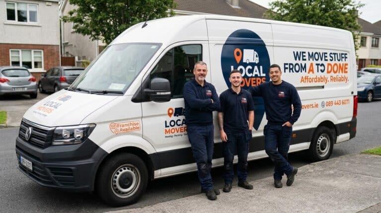 Three smiling local movers stand proudly next to their white van, which reads "Local Movers - We Move Stuff From A To Done Affordably, Reliably." Franchise opportunities are also advertised on the van.